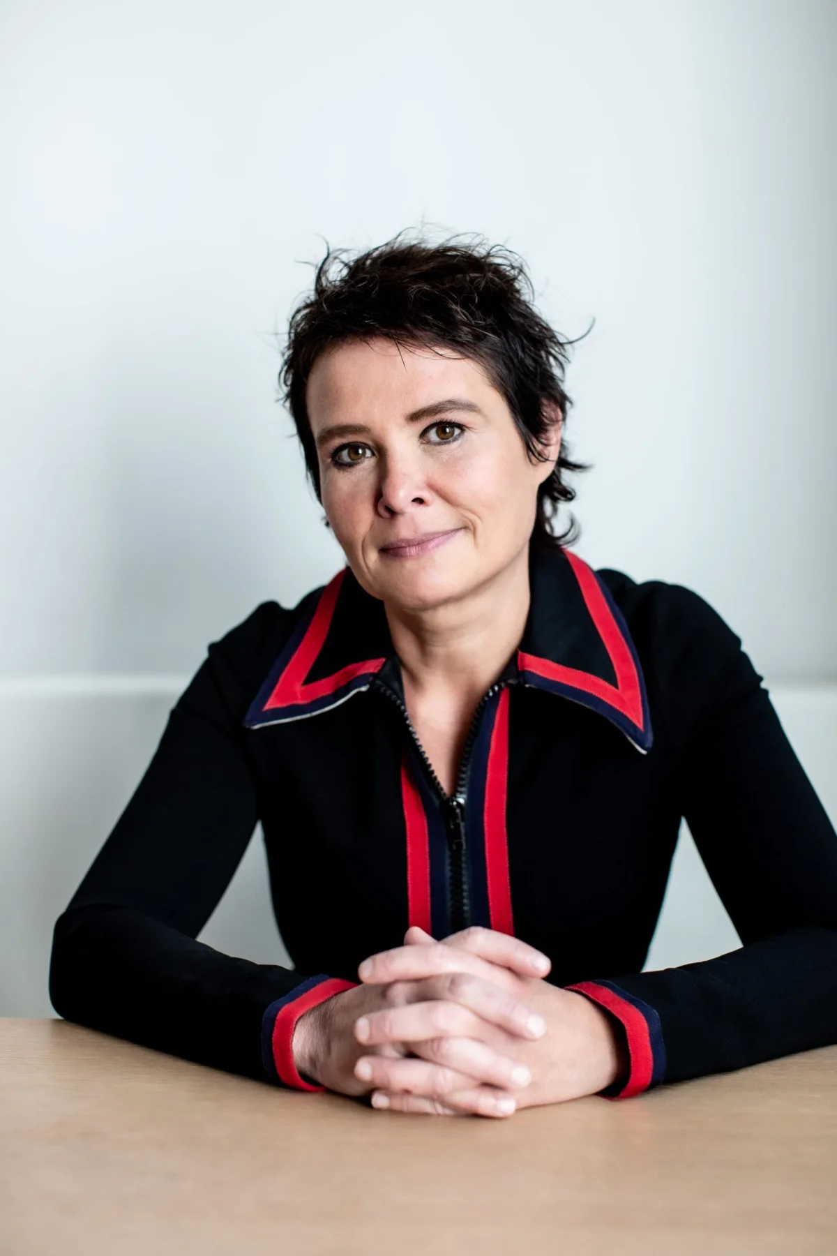 Griet Op de Beeck aan tafel, handen gevouwen
